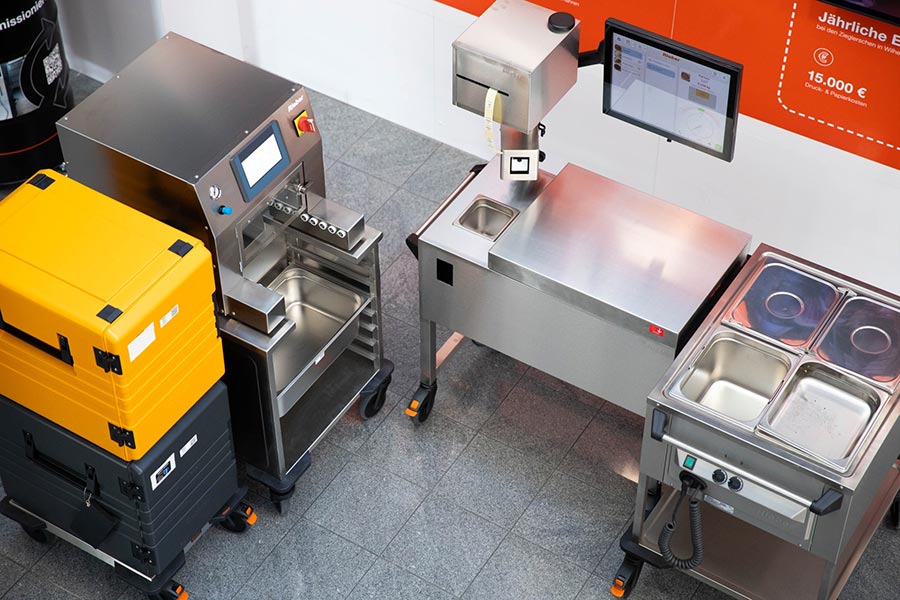 Die GN-Fill-Station und die GN-Cover-Station von Rieber bilden den digital geführten Prozessstart im GN-Auto-Mehrwegsystem: Präzises Befüllen dank der Daten aus dem Warenwirtschaftssystem, darauf folgt das automatische und schwappsichere Verdeckeln – ein reproduzierbarer Mehrwegablauf von Anfang an. Foto: Rieber