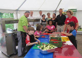  Wokübergabe von Blanco Professional zur Unterstützung des Stadtjugendausschuss’ Karlsruhe (stja): (V.li.) Frank der Koch, Ralph Debes und Martin Kohler (Blanco Professional), Sharareh Shahrokhnia (Vitale Lunchbox gGmbH), Elisabeth Peitzmeier und Irmgard Schucker-Hüttel (stja), Bürgermeister Martin Lenz und eifrige Küchenhelfer. Foto: Yps Knauber